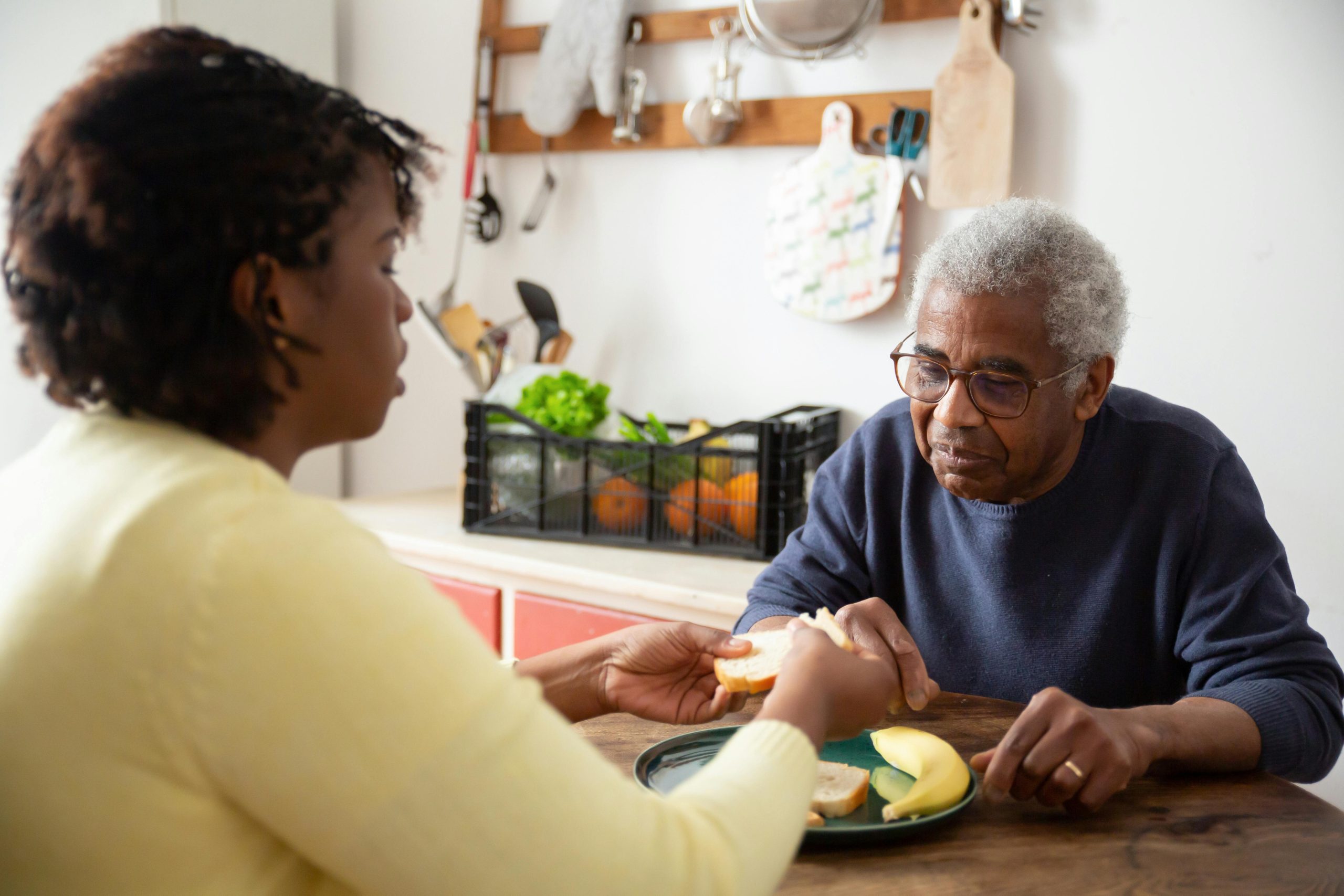 Hands sharing fresh food over a table in a community kitchen