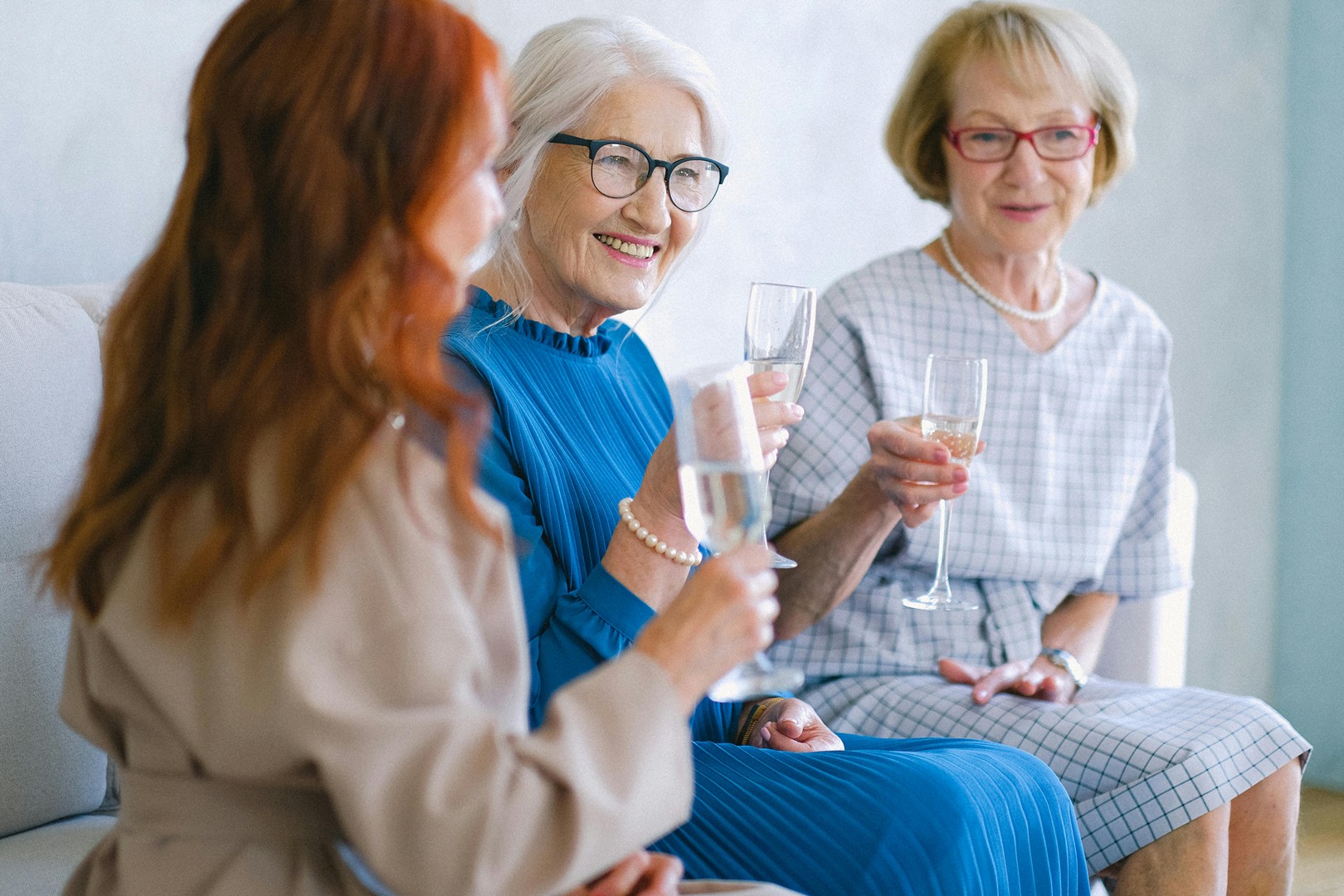 Women chatting and laughing together over drinks at a gathering